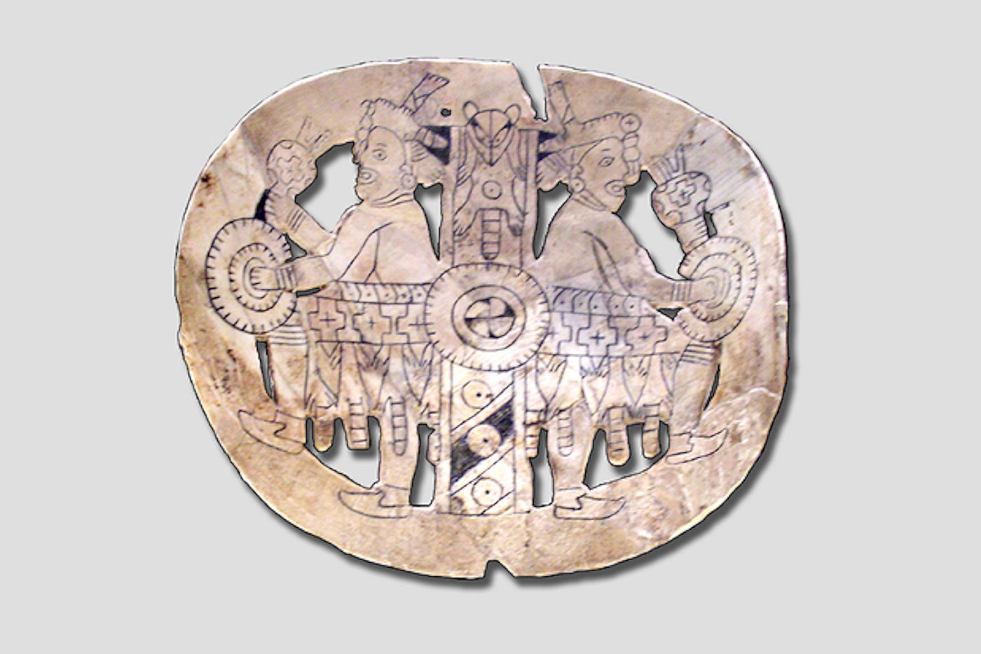 An engraved shell gorget with in the Craig style featuring two "Raccoon dancers", imagery associated with the S.E.C.C. from Spiro Mounds Oklahoma.- History of European Gorget as Native American Trade Items - Crazy Crow Trading Post