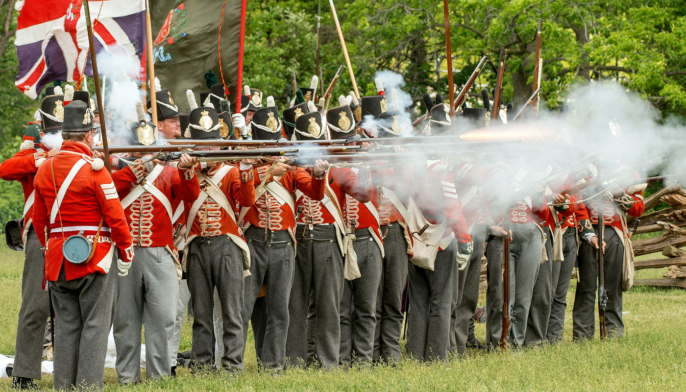Re-enactors (in UK uniforms) fire muskets toward the “American” re-enactors (June 5, 2016) in this annual commemoration of the Battle of Stoney Creek- Crazy Crow Trading Post Re-enactors (in UK uniforms) fire muskets toward the "American" re-enactors (June 5, 2016) in this annual commemoration of the Battle of Stoney Creek- Crazy Crow Trading Post